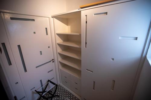 a closet with two white doors and shelves at Dar Lalzohra in Rabat