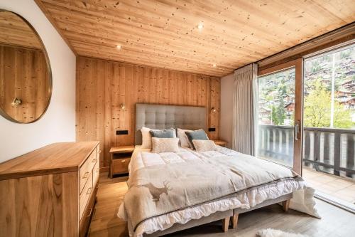 a bedroom with a large bed and a wooden ceiling at Janin 3 Charmant appartement rénové avec 2 chambres et espace cabine in Morzine