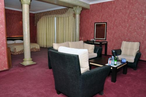 a living room with chairs and a table and a bed at Arena Hotel Gazakh in Qazax