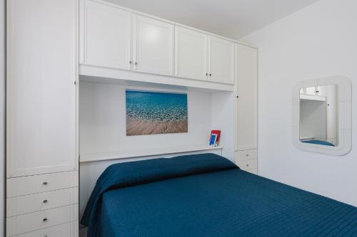 a bedroom with a blue bed and white cabinets at A_mare San Vito Lo Capo in San Vito lo Capo