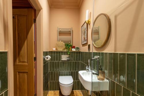 a bathroom with a sink and a toilet and a mirror at The Beach House Boutique Hotel in Sunderland