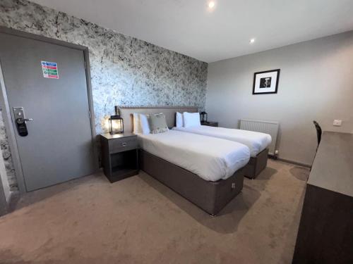 a hotel room with a large bed and a door at Richmond Park Hotel in Boʼness