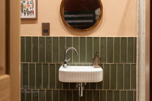 a bathroom with a sink and a mirror at The Beach House Boutique Hotel in Sunderland