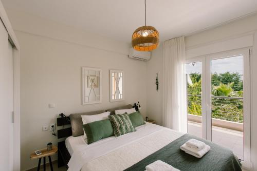 Un dormitorio con una cama grande y una ventana. en Sani Eclectic Family Villa, private garden, en Sani Beach
