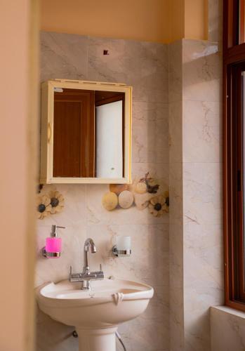 a bathroom with a sink and a mirror at ZnZ Homestay in Shillong