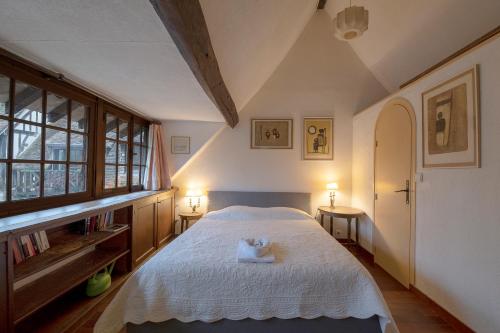 a bedroom with a large white bed with two lamps at Le Moulin d'Andé in Andé
