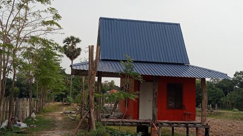a small red house with a metal roof on top at Meta Homestay in Phumĭ Puŏk Chăs