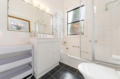 a white bathroom with a shower and a sink at Seafield in Port Fairy