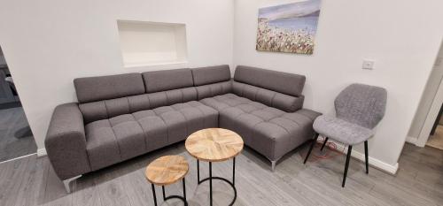 a living room with a couch and two chairs at Modern Living apartment in Balnacart