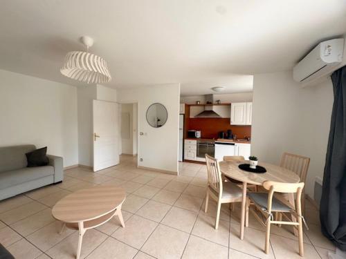 une cuisine et un salon avec une table et des chaises dans l'établissement Appartement Cannes Grand Parc, à Cannes