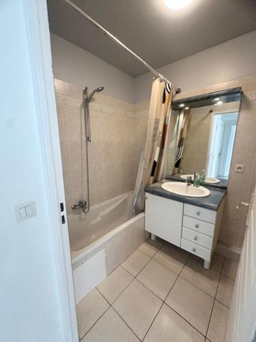 une salle de bain avec un lavabo, une douche et une baignoire dans l'établissement Appartement Cannes Grand Parc, à Cannes
