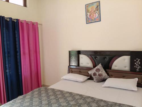 a bedroom with a bed with colorful curtains at Om som home stay hill view in Jāmb
