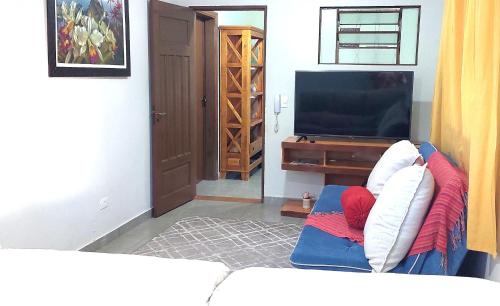 a living room with a couch and a television at Temporada Belas Casas in São Pedro
