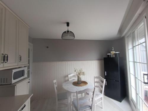a kitchen with a table with chairs and a microwave at Rincón del Mar Terrazas y vistas a la Ría de Vigo in Moaña