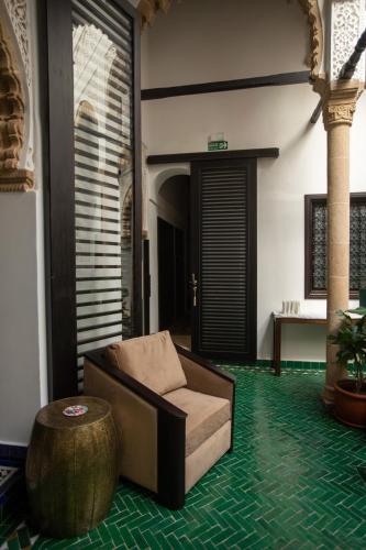 a living room with a chair and a table at Dar Lalzohra in Rabat