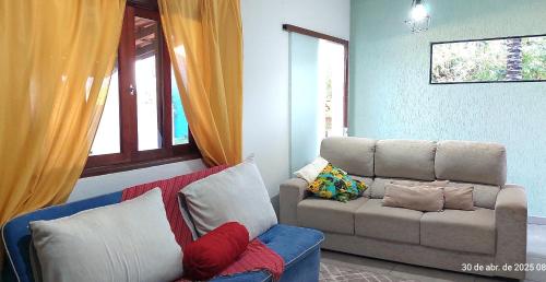 a living room with a couch and a chair at Temporada Belas Casas in São Pedro