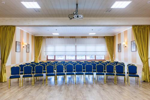 a conference room with blue chairs in front of a window at Seasons SPA Boutique Hotel in Kozin