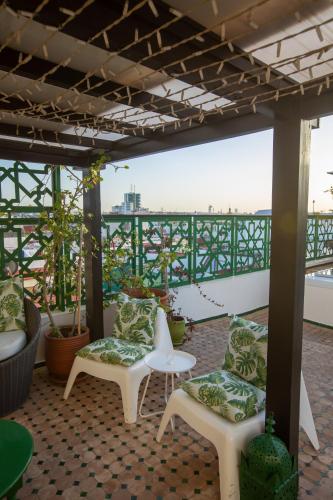 a patio with chairs and a table on a roof at Dar Lalzohra in Rabat