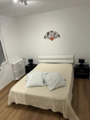 a bedroom with a bed with two pillows on it at Appartement T2 in Dax