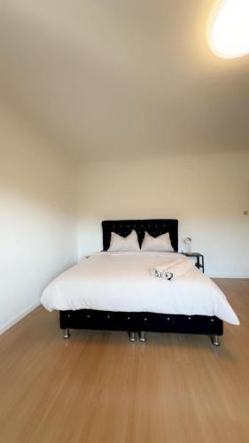 a bedroom with a large bed with white sheets at Spacious 6BR Shared Villa with Garden near Danube For 16 Guests in Vienna