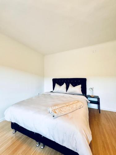 a bedroom with a large bed with white walls at Spacious 6BR Shared Villa with Garden near Danube For 16 Guests in Vienna