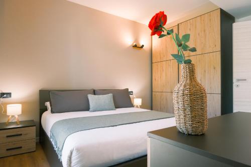 een slaapkamer met een bed en een vaas met een bloem bij Costa Blu - Pool and terrace overlooking the lake in Riva di Solto