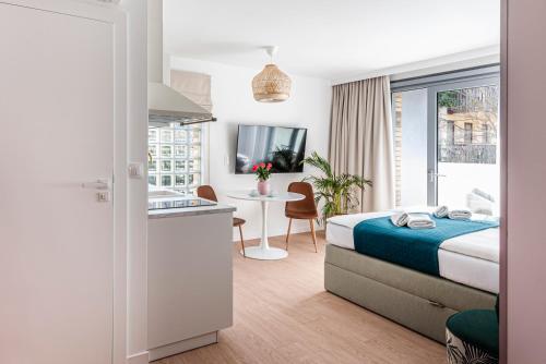 a hotel room with a bed and a sink and a kitchen at Lapwing Residence Sopot in Sopot