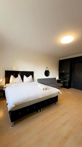 a bedroom with a large bed and a couch at Spacious 6BR Shared Villa with Garden near Danube For 16 Guests in Vienna