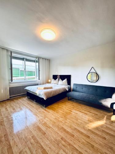 a bedroom with a bed and a couch in it at Spacious 6BR Shared Villa with Garden near Danube For 16 Guests in Vienna