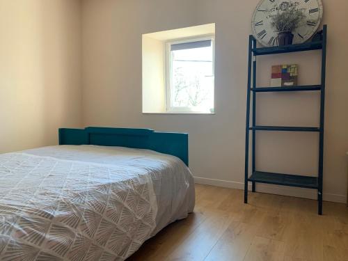 a bedroom with a bed and a clock on the wall at La petite maison dans le Sidobre in Fontrieu