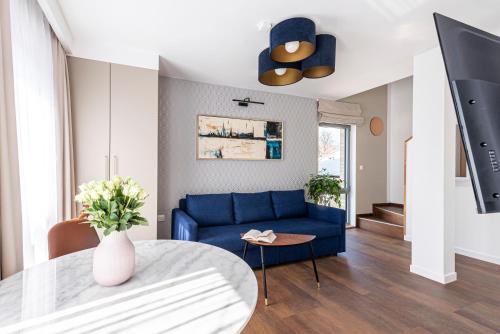 a living room with a blue couch and a table at Lapwing Residence Sopot in Sopot
