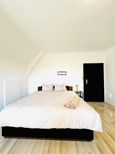 a bedroom with a large bed with white sheets at Spacious 6BR Shared Villa with Garden near Danube For 16 Guests in Vienna