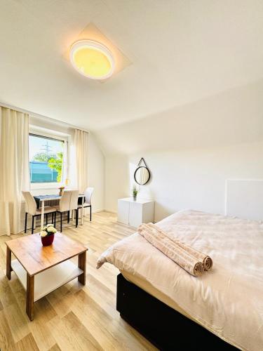 a white bedroom with a bed and a table at Spacious 6BR Shared Villa with Garden near Danube For 16 Guests in Vienna
