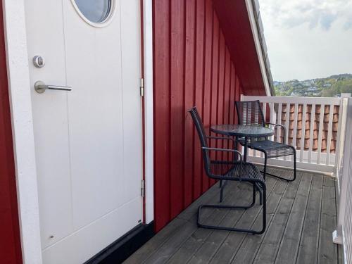 two chairs and a table on a porch at Charming studio apartment in Skarvedalen