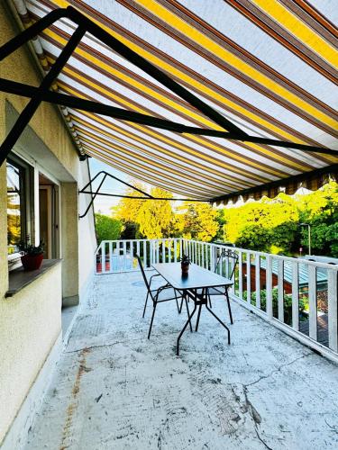 a patio with a table and chairs on a balcony at Spacious 6BR Shared Villa with Garden near Danube For 16 Guests in Vienna