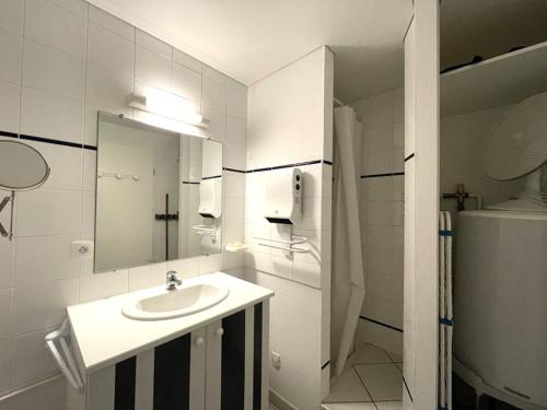 une salle de bain blanche avec un lavabo et un miroir dans l'établissement Studio à Vieux-Boucau, proche commerces, parking sécurisé - FR-1-379-175, à Vieux-Boucau-les-Bains
