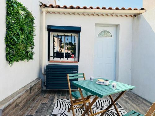 - une table et des chaises sur une terrasse avec une porte dans l'établissement La petite Maison, à Ensuès-la-Redonne