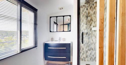 une salle de bain avec un lavabo bleu et un miroir dans l'établissement La petite Maison, à Ensuès-la-Redonne