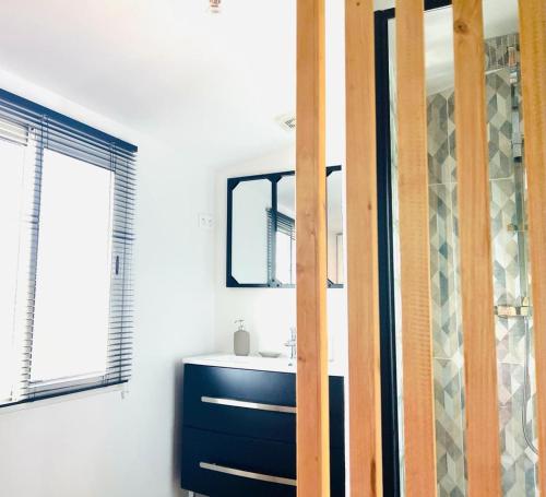 une salle de bain avec un lavabo et un miroir dans l'établissement La petite Maison, à Ensuès-la-Redonne