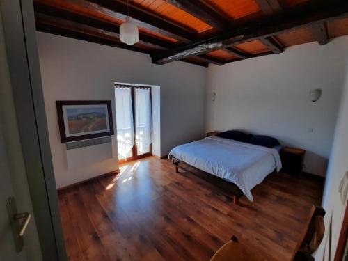 ein Schlafzimmer mit einem Bett und einem Holzboden in der Unterkunft Maison de village au pied de la montagne in Lumbin