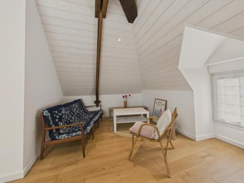 Cette chambre mansardée comprend deux chaises et une table. dans l'établissement Le port et les plages à pied pour 6 personnes, à Piriac-sur-Mer