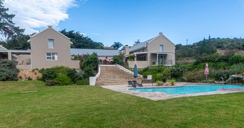 a house with a swimming pool in a yard at The Suites at Waterryk Eco Guest Farm in Stilbaai