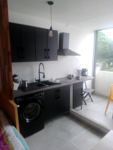 een keuken met een spoelbak en een wasmachine bij Les Appartements De Lina - Trianon 38 - Self Check-In - in La Grande-Motte