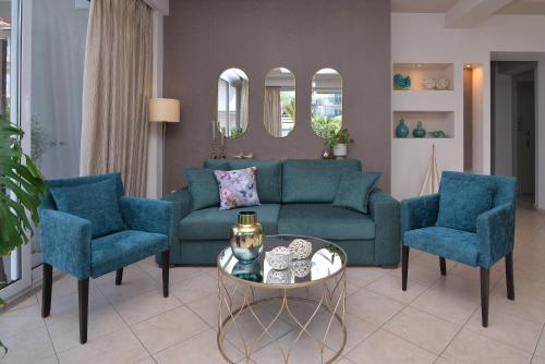 a living room with a couch and two chairs and a table at Irida Apartments in Leptokaria