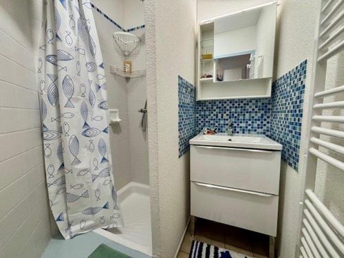 La petite salle de bains est pourvue d'une douche et d'un lavabo. dans l'établissement Appartement T2 à Quiberon avec Piscine, Jardin et Animaux Acceptés - FR-1-478-308, à Quiberon