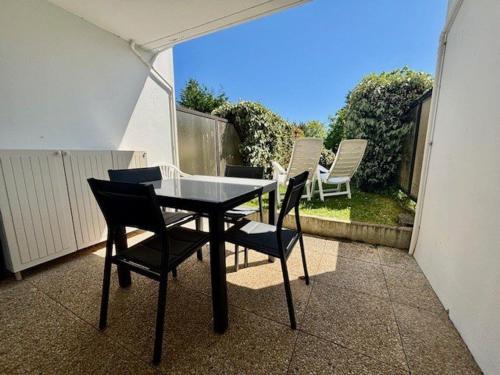 une table noire et des chaises sur un balcon dans l'établissement Appartement T2 à Quiberon avec Piscine, Jardin et Animaux Acceptés - FR-1-478-308, à Quiberon