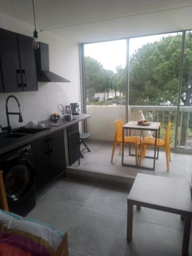 une cuisine et une salle à manger avec une table et des chaises dans l'établissement La Cachette 38, à La Grande Motte