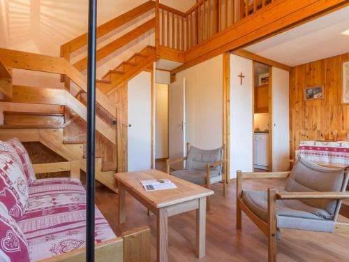 - un salon avec des escaliers, une table et des chaises dans l'établissement Duplex spacieux au coeur de station, proche télécabine, balcon, casier à skis - FR-1-181-2531, à La Plagne Tarentaise