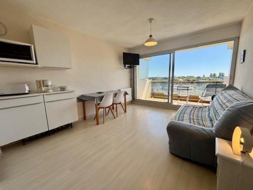 un salon avec un canapé et une table et une cuisine dans l'établissement Studio lumineux 27m² à Quiberon, proche mer - FR-1-478-316, à Quiberon