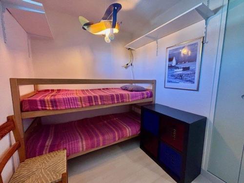 - une petite chambre avec des lits superposés et une télévision dans l'établissement Studio lumineux 27m² à Quiberon, proche mer - FR-1-478-316, à Quiberon